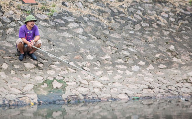Người dân thong thả ngồi câu cá bên bờ sông Tô Lịch